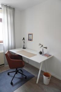 - Escritorio blanco con silla en la habitación en Wohnen im alten Standesamt en Pasewalk