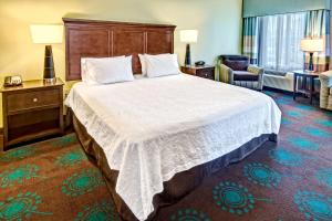 a hotel room with a large bed and a chair at Hampton Inn & Suites Destin in Destin