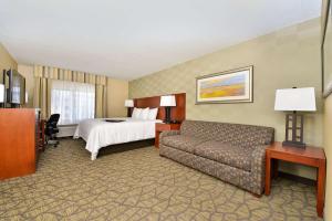 a hotel room with a bed and a couch at Hampton Inn Detroit/Auburn Hills South in Auburn Hills