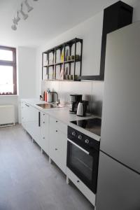 cocina con armarios blancos y fogones negros en Wohnen im alten Standesamt en Pasewalk