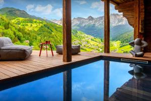 a house with a swimming pool in the mountains at Chalet Happyview - OVO Network in Le Grand-Bornand