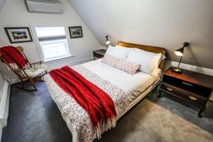 een slaapkamer met een bed met een rode deken erop bij The Lunenburg Inn in Lunenburg