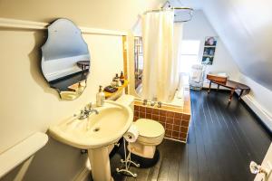 een badkamer met een wastafel, een toilet en een spiegel bij The Lunenburg Inn in Lunenburg