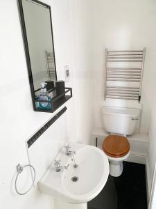 a bathroom with a toilet and a sink and a mirror at The Post House in Charlestown