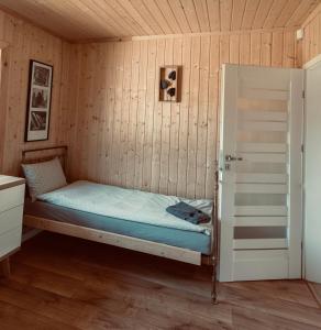 um quarto com uma cama numa parede de madeira em Brzozowa Aleja em Radawa