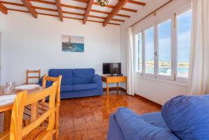 salon z niebieską kanapą i stołem w obiekcie Voramar Waterfront w mieście Sant Lluis