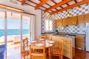 eine Küche und ein Esszimmer mit einem Tisch und Stühlen in der Unterkunft Voramar Waterfront in Sant Lluís