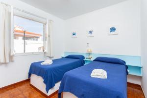 2 Betten in einem Zimmer mit Fenster in der Unterkunft Voramar Waterfront in Sant Lluís