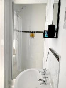 a white bathroom with a sink and a shower at The Post House in Charlestown