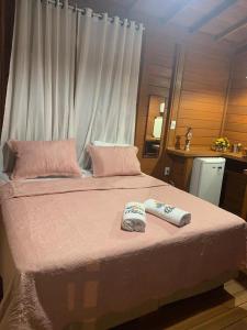 Una cama con dos toallas encima. en Pousada BANGALÔS SOL DE LAGOINHA, en Paraipaba
