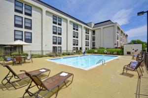 a swimming pool with chairs and a hotel at Hampton Inn Detroit Northville in Northville