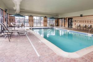 einen großen Pool mit Stühlen und einem Tisch in der Unterkunft Hampton Inn Detroit Roseville in Clinton