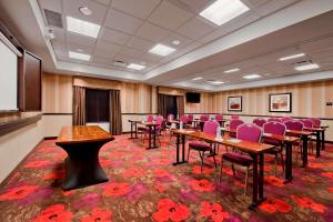 Hampton Inn & Suites Detroit/Airport Romulus في رومولوس: قاعة اجتماعات مع طاولات وكراسي وردية