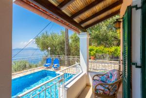 a balcony with a swimming pool and two chairs at Villa Elia in Nisakion