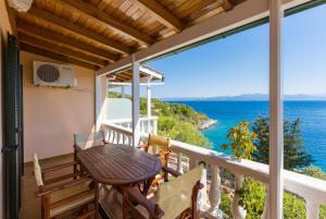 d'un balcon avec une table et une vue sur l'océan. dans l'établissement Dolphin Villa 2, à Porto Ozias
