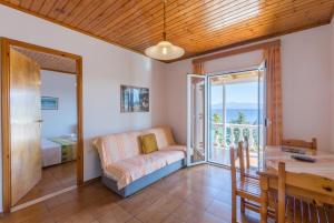 a living room with a table and a couch and a balcony at Dolphin Villa 2 in Porto Ozias