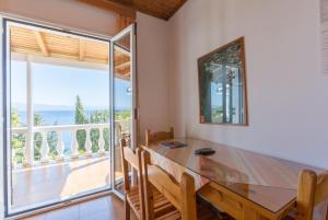 a dining room with a table and a balcony at Dolphin Villa 2 in Porto Ozias
