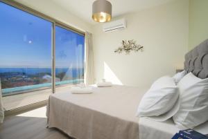 a bedroom with a bed and a large window at Villa Lassi Fos in Kefallonia