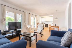 a living room with blue couches and a tv at Villa Binibety in Binibeca