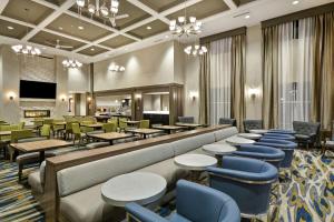 a restaurant with tables and chairs and a lobby at Homewood Suites By Hilton Warren Detroit in Warren