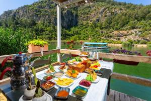a tray of food on a table next to a body of water at Villa Melek Paradise in Dalyan