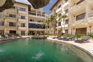 una piscina en medio de un edificio con sillas y una piscina en Grand Laguna Beach Properties by Calisto Stays, en Sosúa