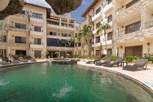 a swimming pool in the middle of a building with chairs and a pool at Grand Laguna Beach Properties by Calisto Stays in Sosúa