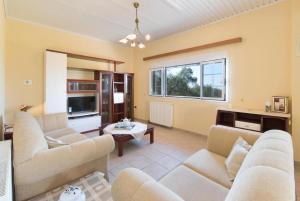 Una sala de estar con sofás y una mesa. en Villa Stephania, en Gáios