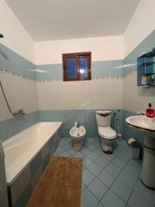 a bathroom with a tub and a toilet and a sink at Cela House in Divjakë