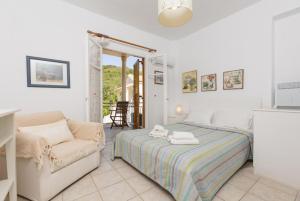 1 dormitorio con 1 cama y 1 silla en Anna Apartment, en Ágios Stéfanos