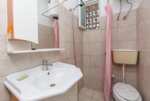 baño con lavabo y cortina de ducha rosa en Anna Apartment, en Ágios Stéfanos