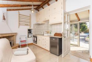 a kitchen with white cabinets and a counter top at Millers Cottage in Vlachopoulátika