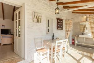a kitchen with a table and chairs in a room at Millers Cottage Large Private Pool AC WiFi in Vlachopoulátika