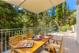 a wooden table and chairs on a deck with trees at Villa Alexandros in Gaios