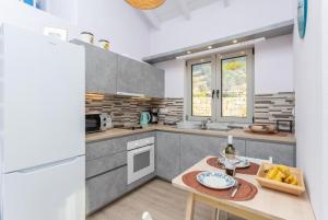 a kitchen with a table and a white refrigerator at Villa Alexandros in Gaios