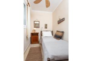 アギオス・ステファノスにあるFoteini Apartmentの小さなベッドルーム(ベッド1台、鏡付)