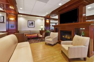 a waiting room with a fireplace and a flat screen tv at Hampton Inn Detroit/Southgate in Southgate