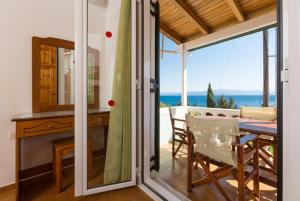 a kitchen with a table and a dining room with a view of the ocean at Dolphin Villa 1 in Porto Ozias
