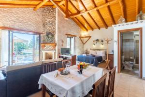 a dining room with a table and a living room at Villa Nionios in Vlachopoulátika +19 photos