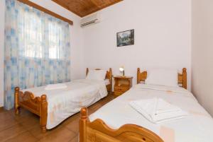 two twin beds in a room with a window at Dolphin Villa 1 in Porto Ozias