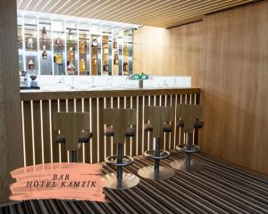 a bar with four chairs in front of a counter at Depandance hotelu Kamzík in Malá Morávka