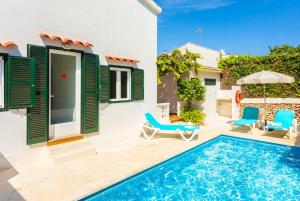 a villa with a swimming pool and a house at Villa Torreta in Punta Prima