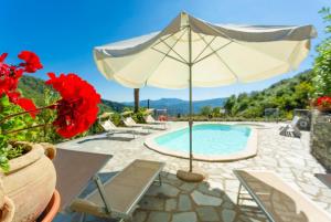 a pool with an umbrella and chairs and a table at Villa Casale Le Selve Large Private Pool WiFi in Lucca