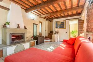 sala de estar con sofá rojo y chimenea en Villa Casale Le Selve, en Lucca