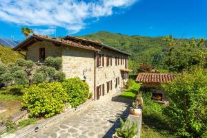 Una antigua casa de piedra con un camino delante de ella. en Villa Casale Le Selve, en Lucca