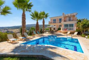 Villa con piscina y palmeras en Villa Astro, en Agia Triada