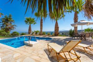 Villa con piscina y palmeras en Villa Astro, en Agia Triada