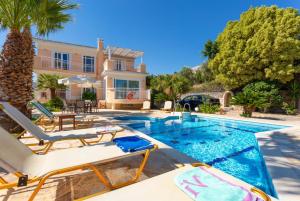 a villa with a swimming pool and a house at Villa Astro in Agia Triada