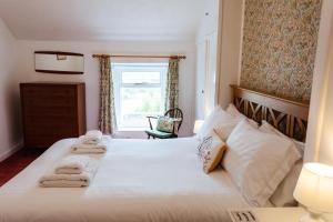 1 dormitorio con 1 cama con toallas en Percy Cottages No4, en Alnmouth