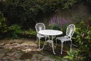 two chairs and a table in a garden at Percy Cottages No4 in Alnmouth